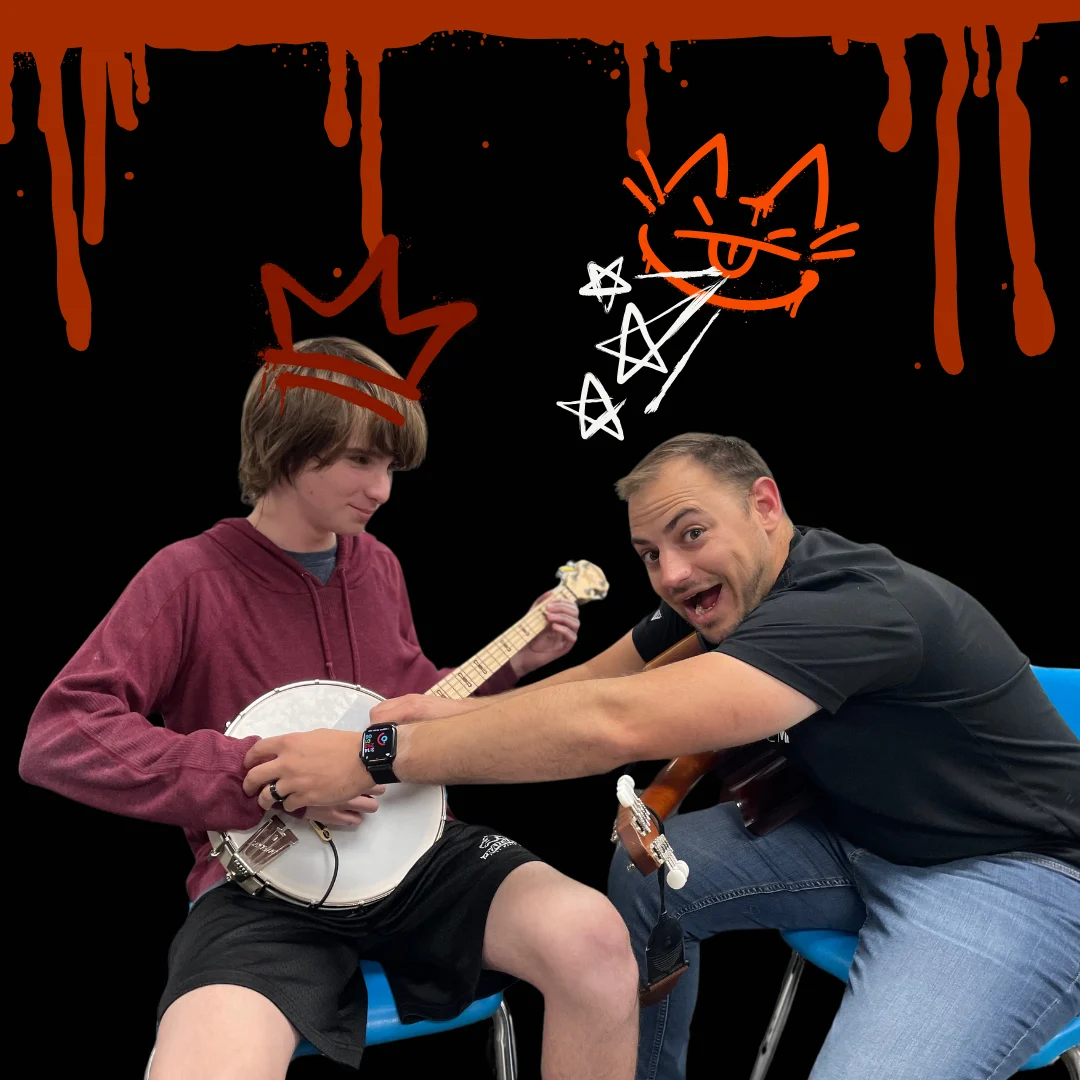 Mr. Garrett helping a student play banjo