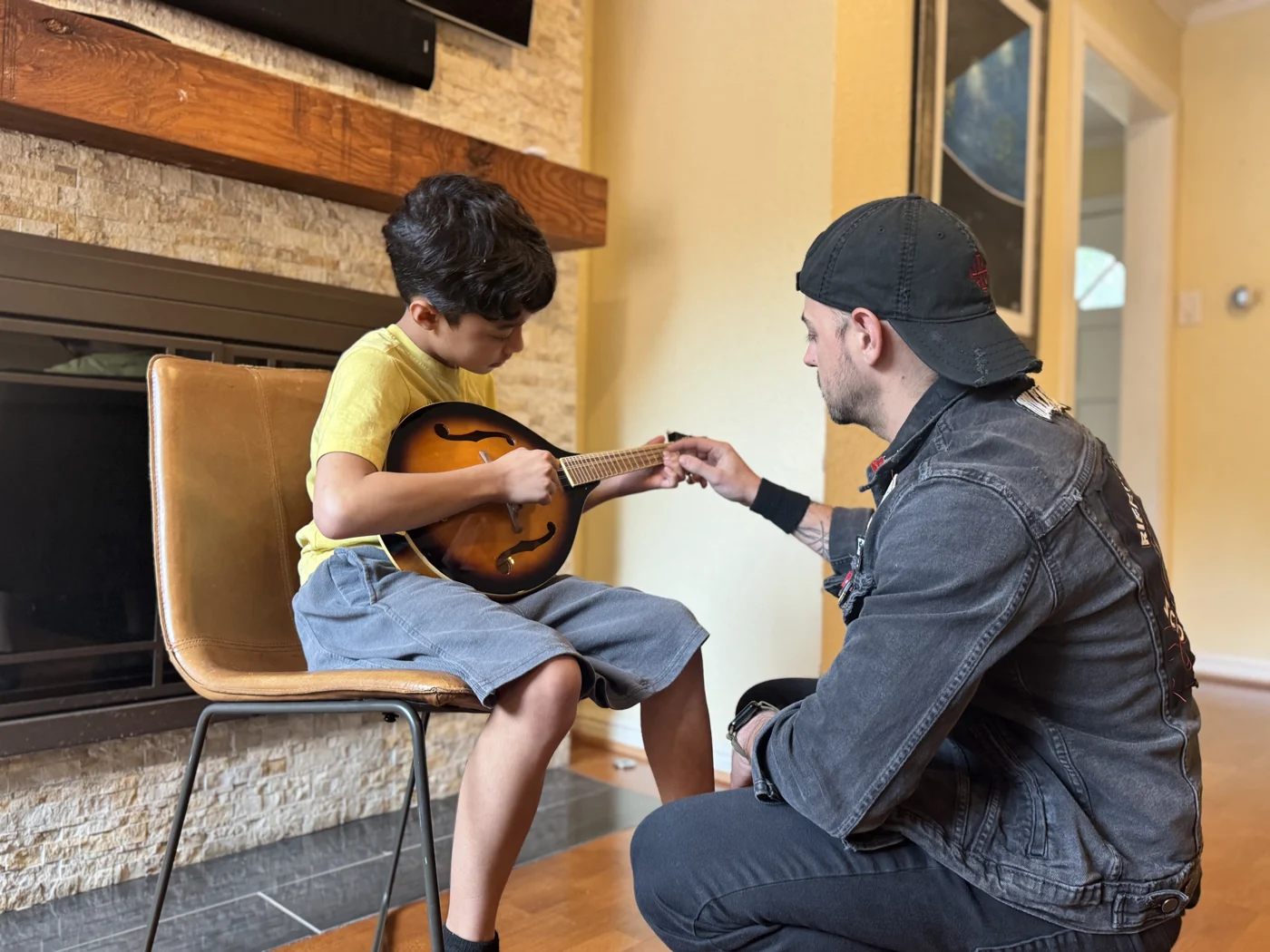 Mr. Garrett helping a young student with mandolin finger placement